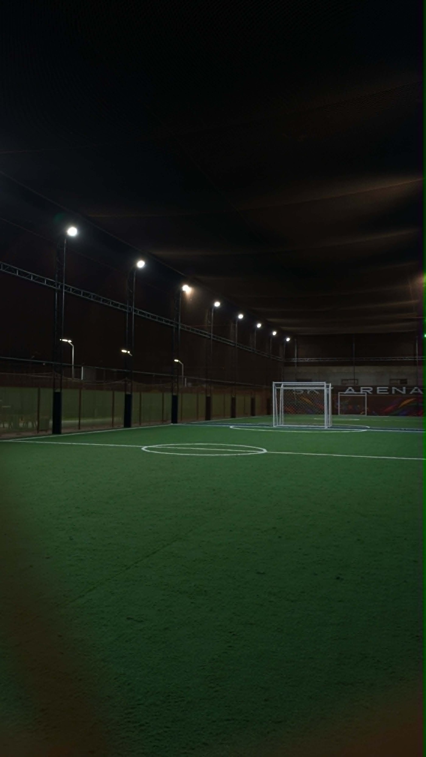 Sky Arena futsal ground at night — floodlit, full markings and goals